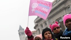 Irene Olmos of Silver Spring, Maryland, waves a "Women's Rights Are Human Rights" flag as she participates in the third annual Women's March at Freedom Plaza in Washington, Jan. 19, 2019. 