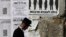 An ultra-Orthodox Jewish man walks past a street poster in Jerusalem's Mea Shearim neighborhood, inviting the public to a protest against government plans to draw more ultra-Orthodox men into the conscript army, June 3, 2013. 