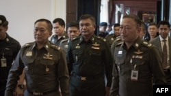 Letjen Manas Kongpan (tengah), perwira tinggi militer Thailand yang dituduh terlibat penyelundupan manusia menyerahkan diri kepada polisi di Bangkok (3/6),