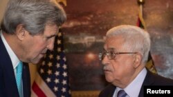 Menlu AS John Kerry (kiri) berbicara dengan Presiden Palestina Mahmoud Abbas di Amman, Yordania Kamis (13/11).