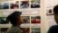 A Myanmar police officer looks at photos displayed during a press conference of Maungdaw Investigation Commission at a government guest house Sunday, Aug.6, 2017, in Yangon, Myanmar. The Myanmar government's inquiry into violence in northern Rakhine state last year that forced tens of thousands of Muslim Rohingya to flee to Bangladesh and led to U.N. accusations of crimes against humanity by the army has concluded that no such crimes happened.
