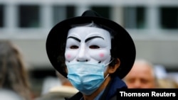A demonstrator wears a Guy Fawkes mask during a protest against the Swiss government's measures to slow down the spread of the coronavirus disease (COVID-19), at the Helvetiaplatz square in Zurich, Switzerland, Aug. 29, 2020. 
