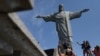 Turistas toman fotos bajo la estatua del Cristo Redentor durante la reapertura del monumento tras el cierre por causa de la pandemia del COVID-19- Río de Janeiro, 15 de agosto 2020. 