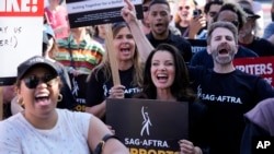 Fran Drescher, center, president of SAG-AFTRA, takes part in a Writers Guild of America rally outside Paramount Pictures studio, Monday, May 8, 2023, in Los Angeles. (AP Photo/Chris Pizzello)