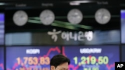 KOSPI, left, and the foreign exchange rate between U.S. dollar and South Korean won at the foreign exchange dealing room in Seoul, South Korea, Tuesday, March 31, 2020.