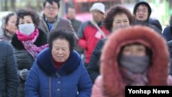 봄을 시샘하는 꽃샘추위가 기승을 부린 10일 서울 종로구 광화문 광장에서 몸을 꽁꽁 싸맨 관광객들이 발걸음을 서두르고 있다.