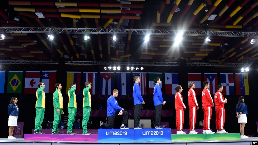 American fencer Race Imboden (4th from L) kneels during the national anthem at the Men's Foil Team medal ceremony in Fencing, at the Lima Convention Center during the Pan American Games Lima 2019, in Lima, Peru, Aug. 09, 2019. 