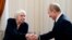 FILE - Russian President Vladimir Putin shakes hands with Lyudmila Alekeyeva, the head of the Moscow Helsinki Group, in Novo-Ogaryovo residence outside Moscow, Jan. 23, 2014. Russia's government is trying to shut the group, according to a website notice seen Dec. 20, 2022.