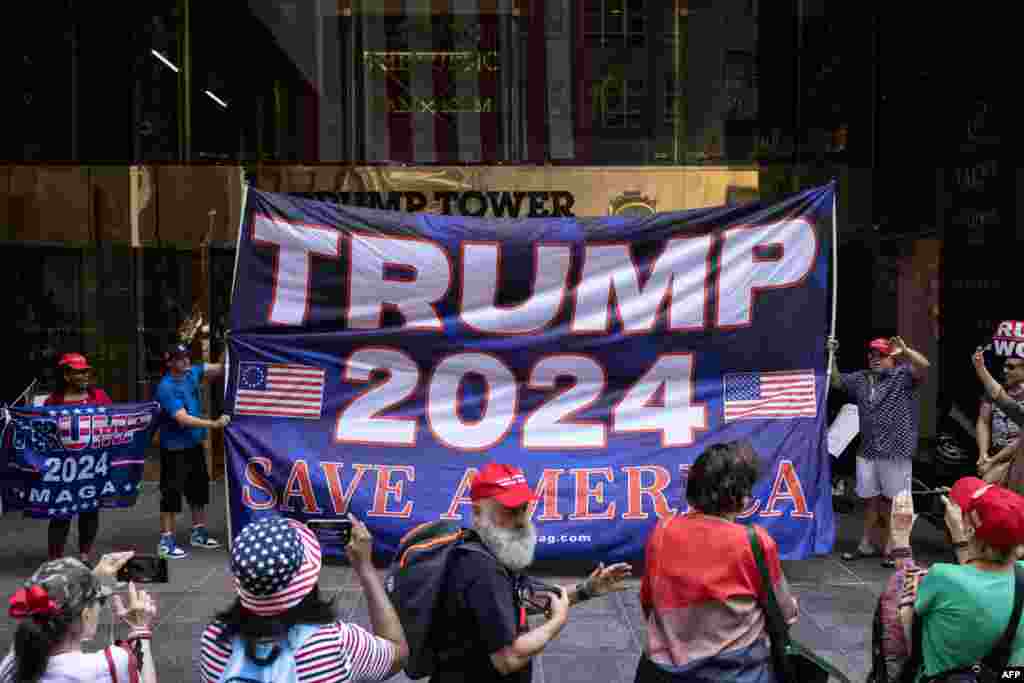 En la imagen, los partidarios del expresidente levantan una bandera durante una manifestación frente a la Torre Trump en la ciudad de Nueva York.