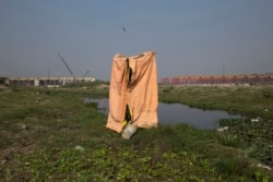 FILE - A make-shift toilet made by farmers for their use is seen near the River Yamuna, in New Delhi, India, Nov. 19, 2015.
