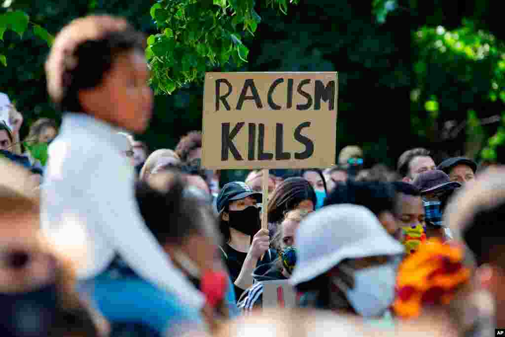 Un ciudadano sostiene un cartel con las palabras &quot;Alto a la violencia policial racista&quot;, frente a la embajada de los Estados Unidos en Berl&#237;n, Alemania.