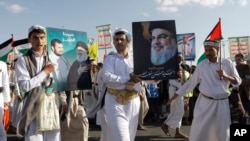 Para pendukung Houthi mengacungkan poster dari pemimpin Hizbullah yang telah meninggal dunia, Hassan Nasrallah, dalam sebuah aksi memperingati satu tahun perang di Jalur Gaza, di Sanaa, Yaman, pada 7 Oktober 2024. (Foto: AP/Osamah Abdulrahman)