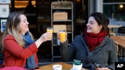 Women enjoy a cafe and an orange juice at a café terrace, May, 19, 2021 in Strasbourg, eastern France. It's a grand day for the French. 