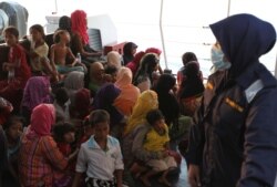 FILE - Rohingya refugees who were intercepted by Malaysian Maritime Enforcement Agency off Langkawi island, wait to be escorted to immigration authorities, at the Kuala Kedah ferry jetty, April 3, 2018.