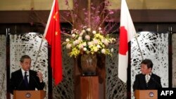 Menteri Luar Negeri China Wang Yi (kiri) dan Menteri Luar Negeri Jepang Toshimitsu Motegi dalam konferensi pers di Tokyo, 24 November 2020.