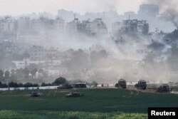 Israeli tanks and other military vehicles maneuver inside the Gaza Strip, as seen from Israel, Oct. 29, 2023.