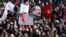 Tunisians hold a placard with an image of the late secular opposition leader Chokri Belaid during his funeral procession in the Jebel Jelloud district in Tunis, February 8, 2013. 