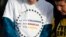 A student wears a printed message during the kickoff event for the Vote For Our Lives movement to register voters, April 19, 2018, at Clement Park in Littleton, Colo. The event was held on the eve of the 19th anniversary of the shootings at Columbine High School.