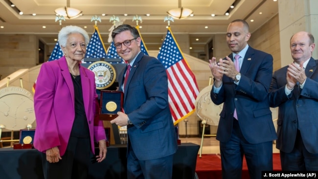 House Speaker Mike Johnson, R-La., center, presents a Congressional Gold Medal to Ann Hammond, daughter of NASA's Dorothy Vaughan, in Washington, Wednesday, Sept. 18, 2024.