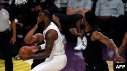 LeBron James, à gauche, et Joël Embiid, Los Angeles, le 18 février 2018.