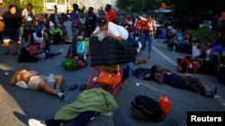 Un menor de Nicaragua, observa a su hermano dormir mientras descansan mientras participan en una caravana que se dirige a la frontera de Estados Unidos, en Huixtla, México, el 27 de noviembre de 2021.