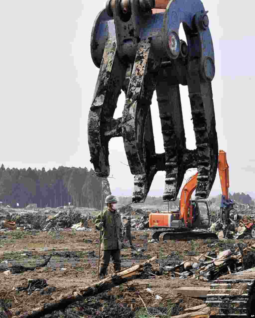 Japanese Self-Defense Force soldiers remove debris and searches for people missing since the March 11 tsunami in the city of Minamisoma in Fukushima prefecture, May 2, 2011. (AFP)
