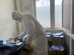 FILE - A member of medical staff wearing protective equipment, prepares to take care of patients amid the spread of the coronavirus disease (COVID-19), at an hospital in Douala, Cameroon, April 27, 2020.