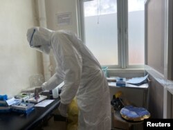 A member of medical staff wearing protective equipment, prepares to take care of patients amid the spread of the coronavirus disease (COVID-19), at an hospital in Douala, Cameroon, April 27, 2020.