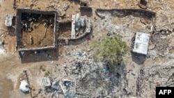 This picture shows an aerial view of people inspecting the damage at a site targeted by airstrikes, carried out the night before by Jordan on the village of Al-Taf in the Al-Lajat region, located in the northeastern countryside of Daraa, on October 27, 2026.