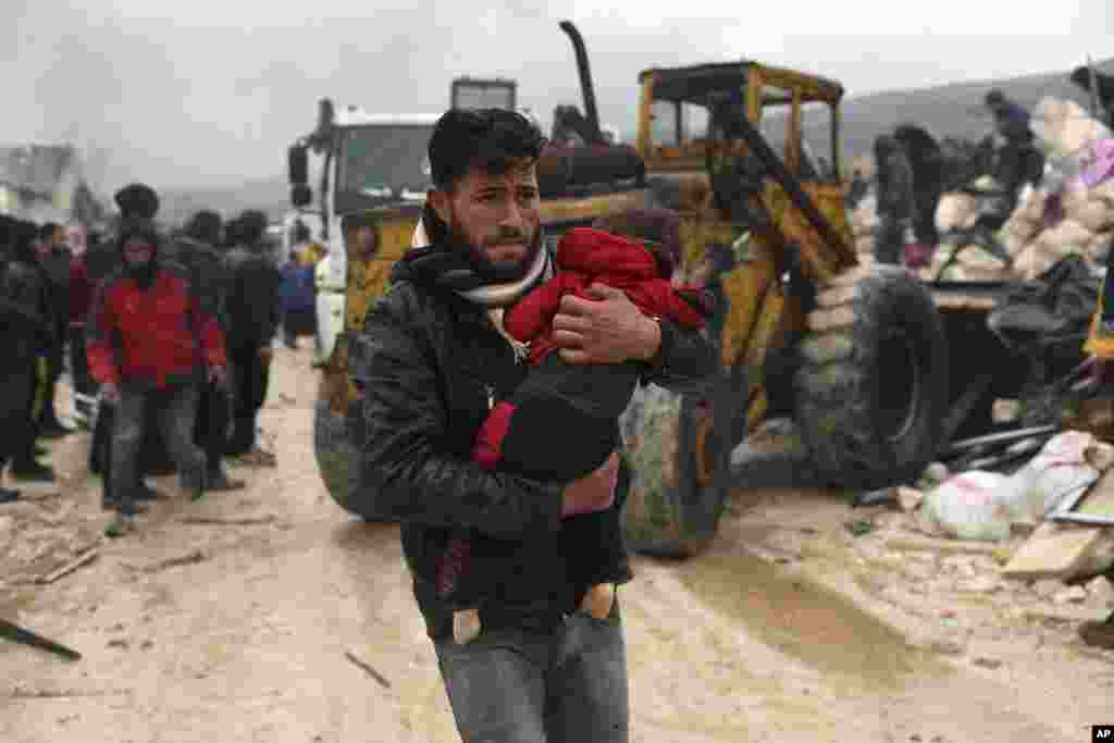 A man carries the body of an earthquake victim in the Besnia village near the Turkish border, Idlib province, Syria, Feb. 6, 2023.&nbsp;