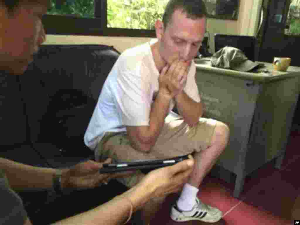 In this photo taken Tuesday, Sept. 16, 2014 and released by Royal Thai police, Christopher Ware, a British friend of British tourist David Miller who was killed along with his girlfriend, reacts during an investigation at a police station in the resort island of Koh Tao in the Gulf of Thailand. Police said Wednesday, Sept. 17, they have conducted autopsies on the two British tourists whose bludgeoned bodies were found on the island this week. (AP Photo/Royal Thai Police) 