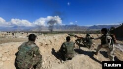 FILE - Afghan security forces take position during a gun battle between Taliban and Afghan security forces in Laghman province, Afghanistan, March 1, 2017. 