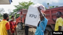 Seorang pria membawa kotak suara persiapan pelaksanaan Pilkada di tengah pandemi COVID-19 di Keerom, Provinsi Papua, 8 Desember 2020. (Foto: Antara /Indrayadi TH via Reuters).