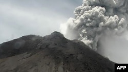 This handout picture taken and released March 27, 2020, by Indonesia's disaster mitigation agency (BNPB) shows Mount Merapi volcano spewing thick volcanic ash, as seen from Yogyakarta.