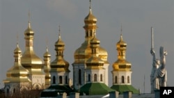 FILE - Golden cupolas of the 11th century Monastery of the Caves, holiest site of Orthodox Christians, beside the Soviet-era 62-meter tall Motherland statue, Kyiv.