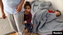 Libyan displaced children, who fled their house because of the fighting between the Eastern forces commanded by Khalifa Haftar and the internationally recognized government, are seen at an industrial complex which is used as a shelter, in Tripoli, Libya, 