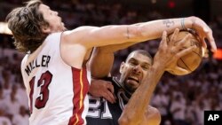 Tim Duncan de los San Antonio Spurs es bloqueado por Tim Duncan del Miami Heat, en el sexto juego ganado por Miami.