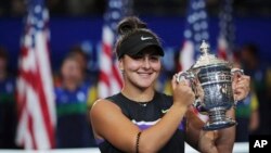 Bianca Andreescu of Canada holds up the championship trophy after defeating Serena Williams of the United States in the women's singles final of the U.S. Open tennis championships, Sept. 7, 2019, in New York.