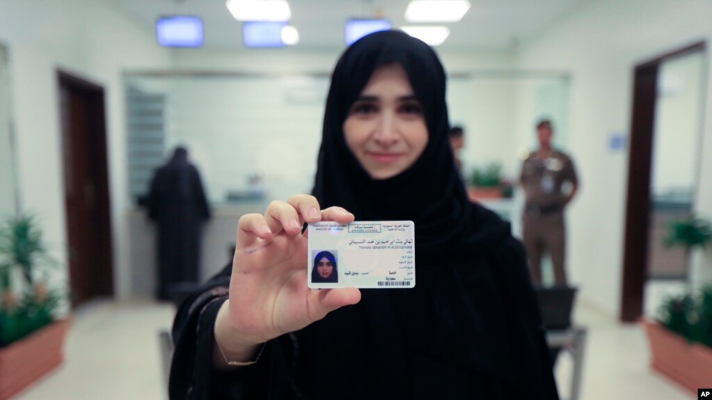 This image released by the Saudi Information Ministry shows Tahani Aldosemani, assistant professor at Prince Sattam Bin Abdulaziz University in Al-Kharj, as she displays her new driving license at the General Department of Traffic in the capital, Riyadh, June 4, 2018.