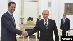 El presidente ruso, Vladimir Putin (derecha) estrecha la mano del presidente sirio, Bashar al-Assad durante una reunión en el Kremlin, en Moscú, el martes, 20 de octubre de 2015.