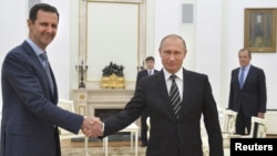 Russian President Vladimir Putin (R) shakes hands with Syrian President Bashar al-Assad during a meeting at the Kremlin in Moscow, Russia, Oct. 20, 2015.