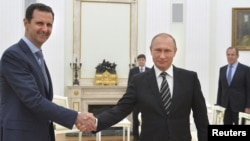 FILE - Russian President Vladimir Putin (R) shakes hands with Syrian President Bashar al-Assad during a meeting at the Kremlin in Moscow, Russia, Oct. 20, 2015.