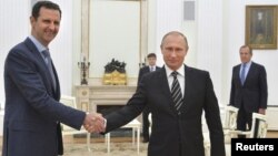 ປະທານາທິບໍດີຣັດເຊຍ ທ່ານ Vladimir Putin (ຂວາ) ຈັບມືກັບ ປະທານາທິບໍດີຊີເຣຍ ທ່ານ Bashar al-Assad ລະຫວ່າງ ກອງປະຊຸມ ທີ່ວັງ Kremlin ໃນນະຄອນມົສກູ.