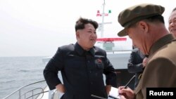 El líder norcoreano, Kim Jong Un, observa una prueba de un misil balístico submarnio. 