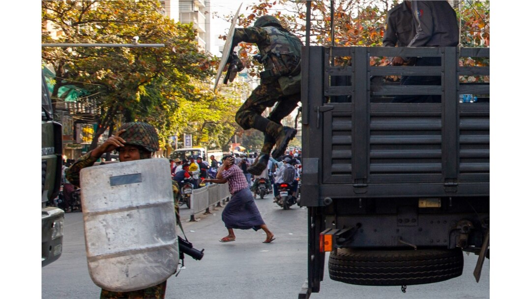 Seorang laki-laki berlari saat tentara turun dari kendaraan saat bentrokan terjadi.