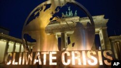 Una escultura de metal frente a la Puerta de Brandenburgo, en Berlín, el martes 11 de diciembre de 2018, mientras activistas de Greenpeace protestan contra estrategia alemana contra calentamiento global.