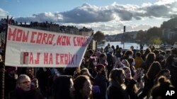 مرکزی فرانس کے شہر لیون میں ہفتہ، 27 نومبر، 2021 کو ایک مظاہرے کے دوران لوگوں نے بینرز اٹھائے ہوئے ہیں جن میں خواتین کے خلاف تشدد کی روک تھام کے لیے مزید حکومتی کارروائی کا مطالبہ کیا گیا ۔ اے پی فوٹو