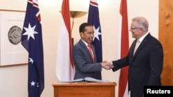 Presiden Joko Widodo (kiri) berjabat tangan dengan PM Australia Scott Morrison di Gedung Parlemen di Canberra, Australia, 10 Februari 2020. 