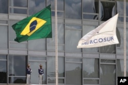The Brazilian national flag along with a MERCOSUR banner fly at half-staff to honor plane crash victims, outside the Planalto Presidential Palace in Brasilia, Brazil, Nov. 29, 2016.