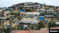 FILE - A Rohingya refugee repairs the roof of his shelter at the Balukhali refugee camp in Cox's Bazar, Bangladesh, March 5, 2019.